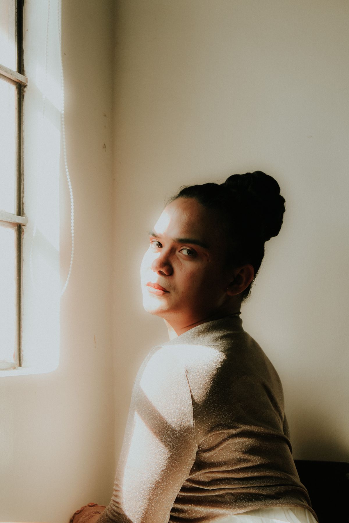 A woman lit by soft window light, calm and unhurried
