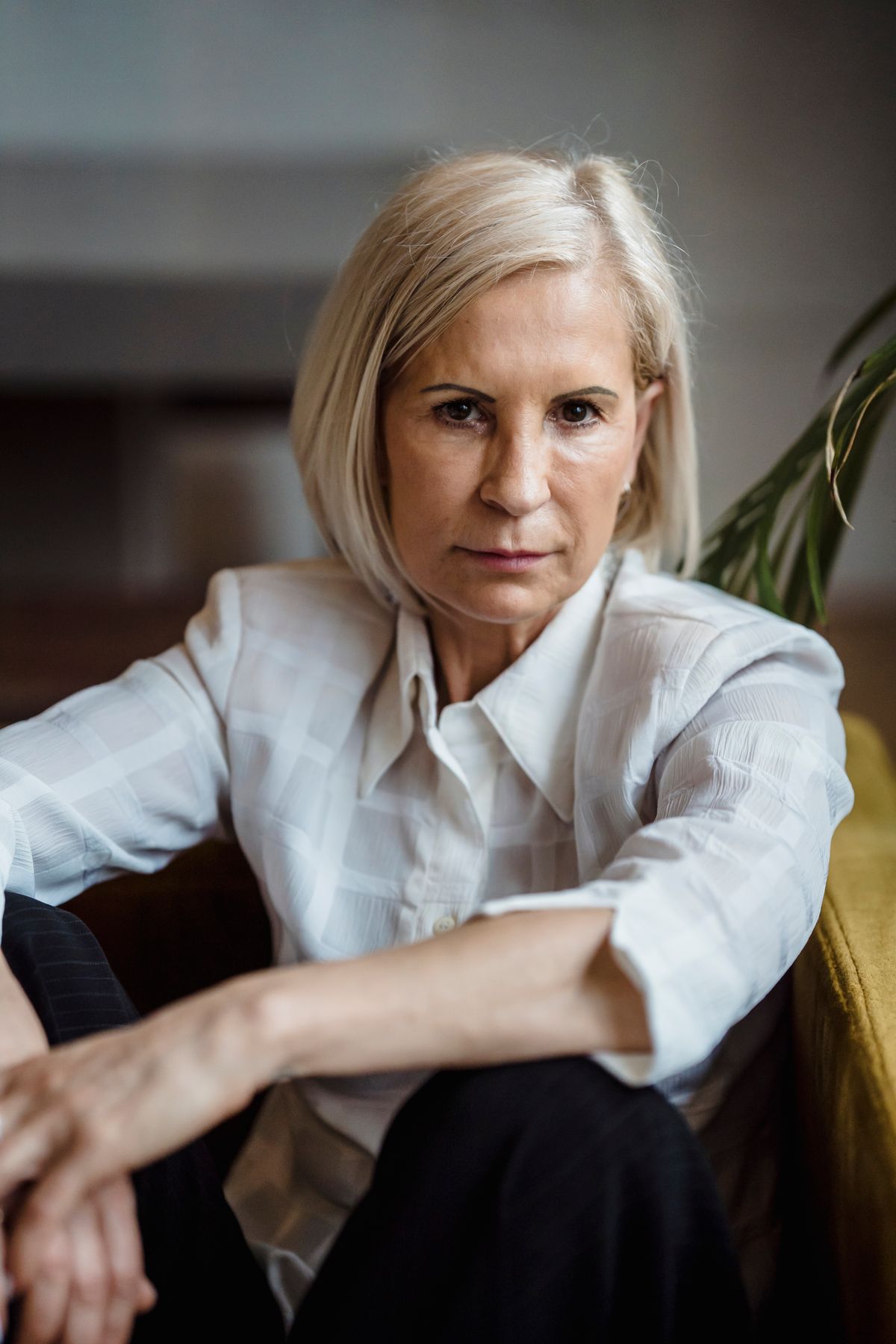 A woman in her fifties in window light, meeting the camera with a steady, direct gaze
